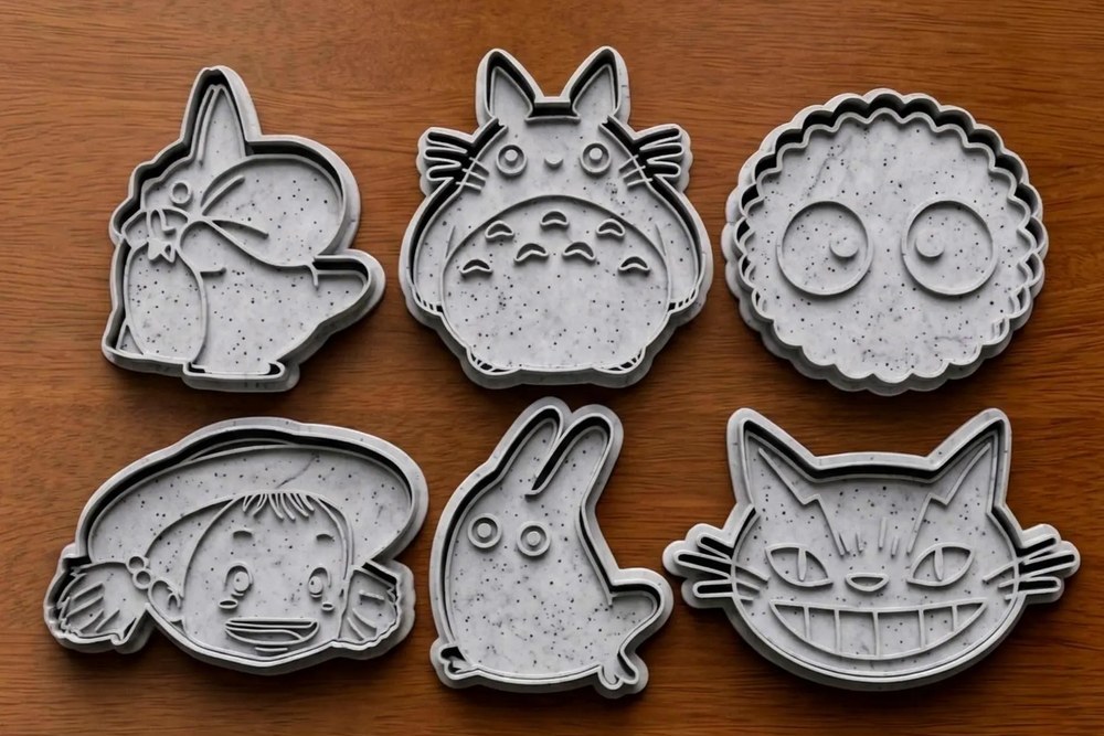 Six food-safe 3D-printed My Neighbour Totoro character cookie cutters laid out on a wooden table - Stamp and Bake